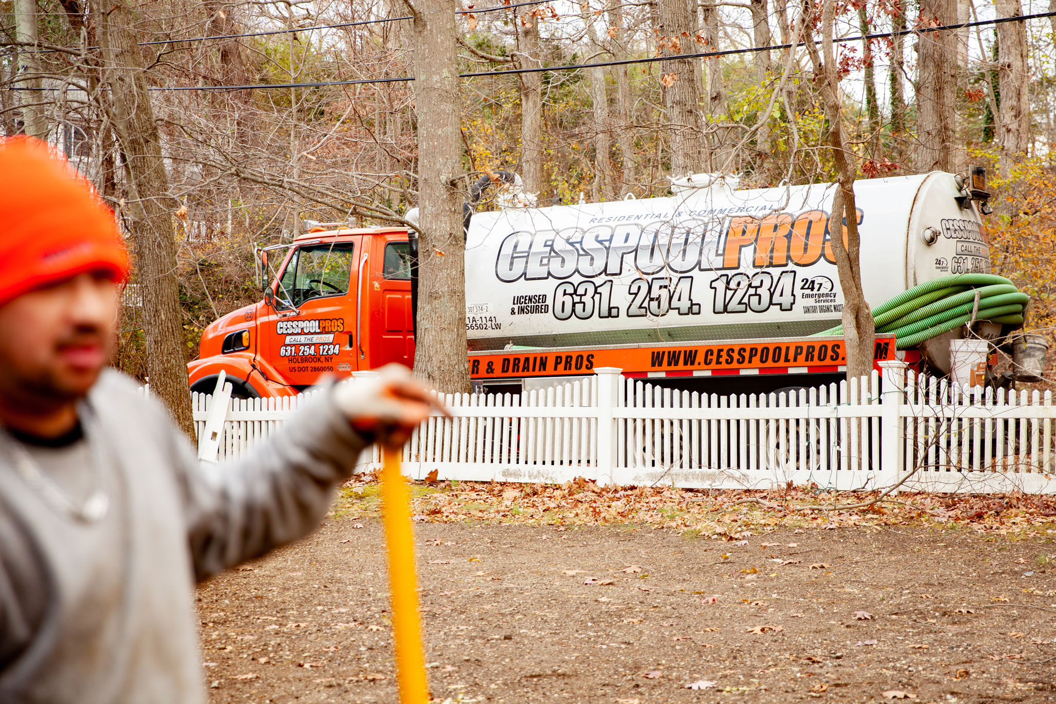 Cesspool Pros truck on the street with worker in the foreground